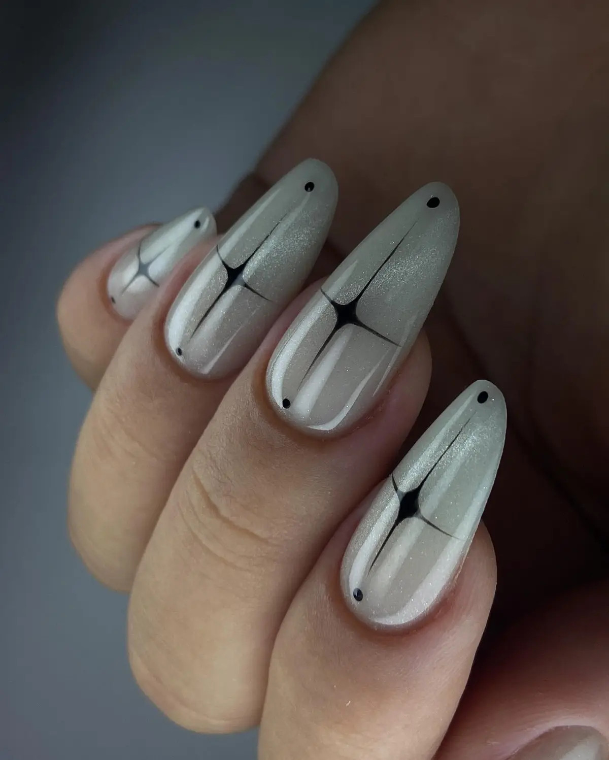Unhas longas amendoadas em cinza perolado, com traços pretos finos.
